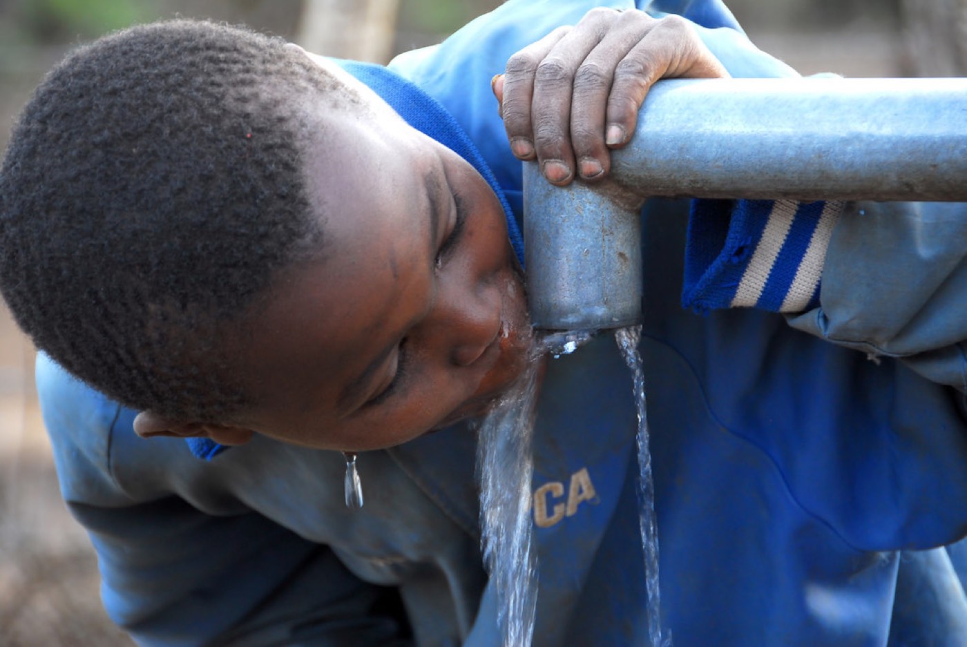 A child drinking clean water from a borehole tap