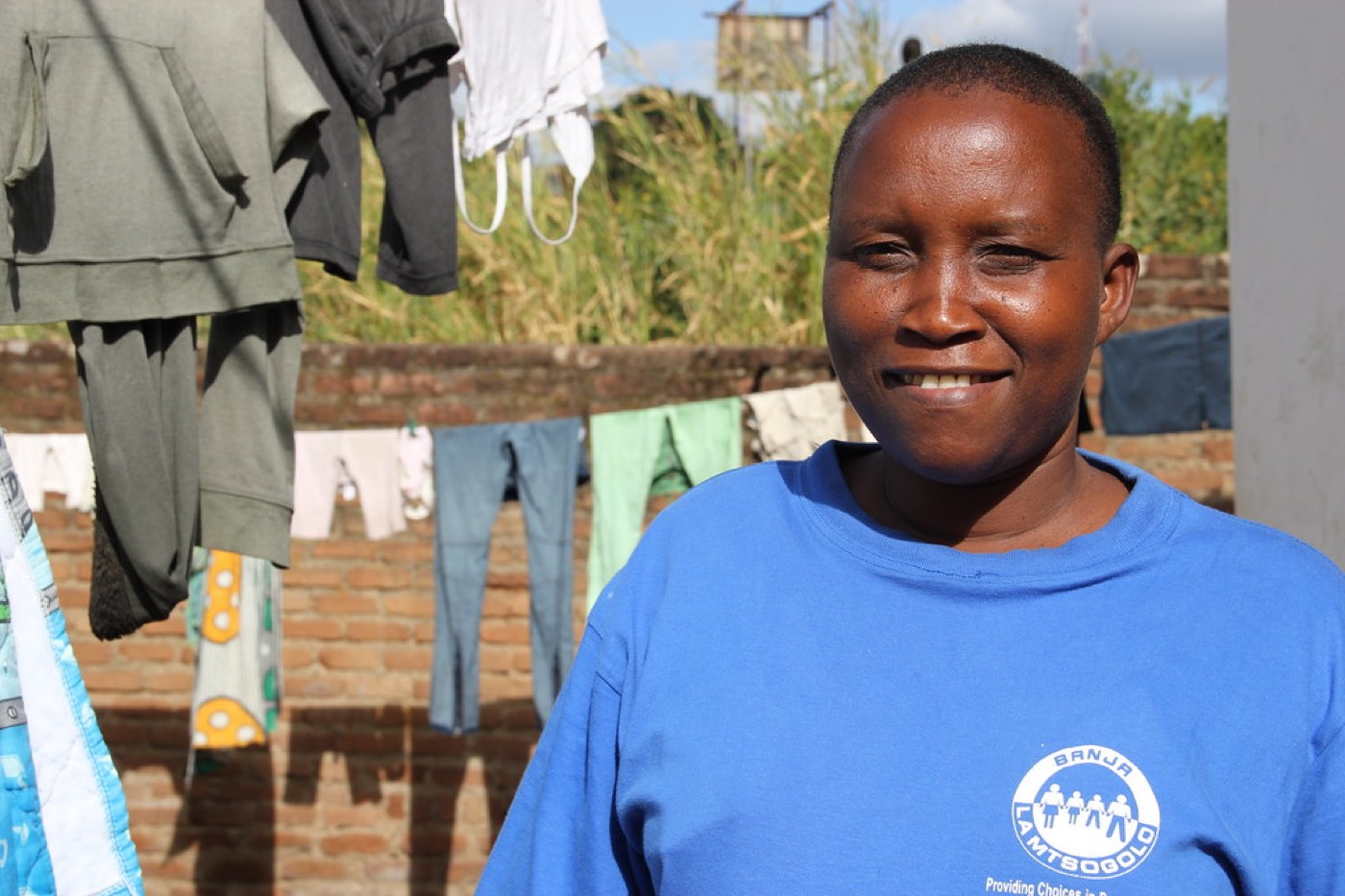 A community health worker outside a home in the community